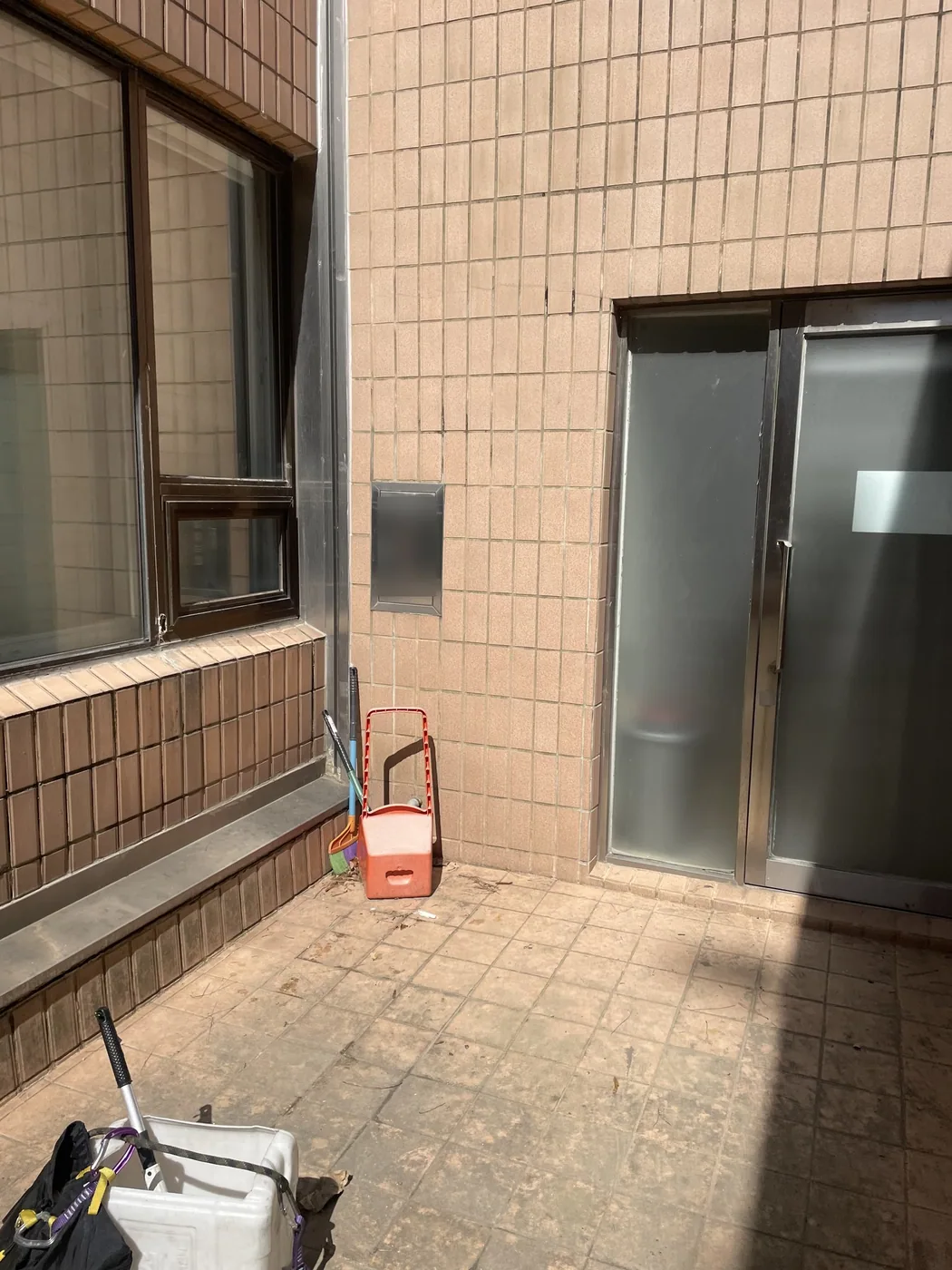 마당 출입문 옆 바닥에 놓인 세척 통과 장비 가방, 손수레