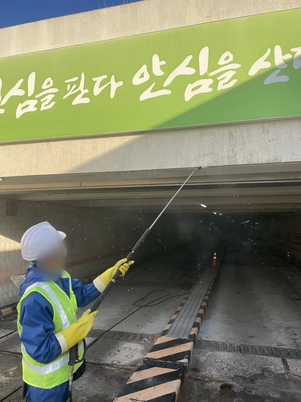 작업자가 개구부 안쪽 벽면의 자국 부위를 겨냥해 세척하는 장면