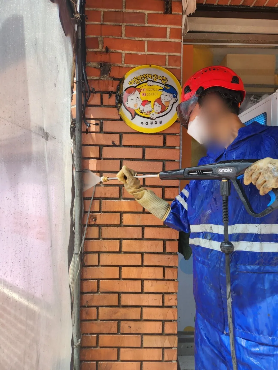 벽돌 기둥 모서리에 노즐 거리를 맞춰 세척하는 장면