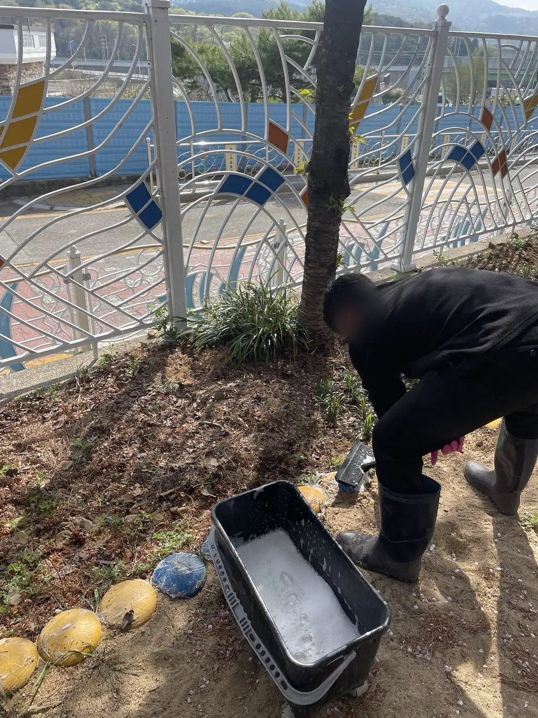 작업 도구를 옆에 두고 경계 구간을 손으로 정리하는 장면