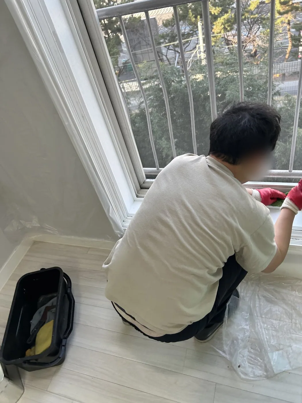 창틀 하부의 굳은 오염 부분을 가까이에서 작업하는 장면